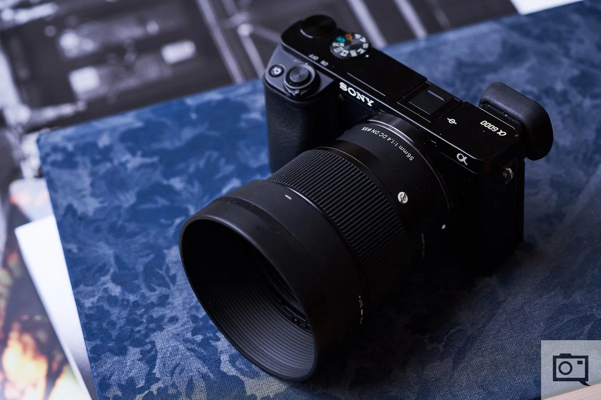 Объектив Sigma 56mm f/1.4 DC DN Contemporary с блендой на камере Sony с матрицей APS-C, вид спереди